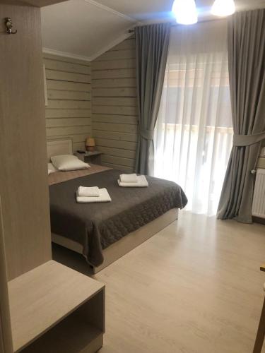 ein Schlafzimmer mit einem Bett, auf dem zwei Handtücher liegen in der Unterkunft Pogar White in Slawske