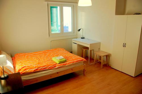 a bedroom with a bed and a desk and a window at Big Villa in Sainte-croix in Sainte-Croix