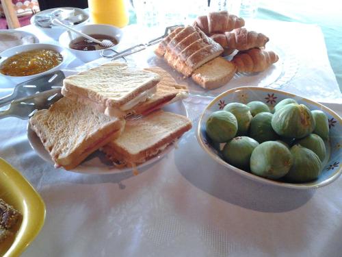 a table with a plate of sandwiches and a bowl of bread at Archontiko Pantou in Portariá