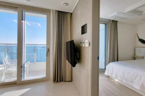 a bedroom with a bed and a view of the ocean at Hyoi Stay Busan Songdo in Damyang