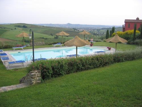 a large swimming pool with umbrellas and chairs at Agriturismo Borgo Vigna Vecchia in Cerreto Guidi