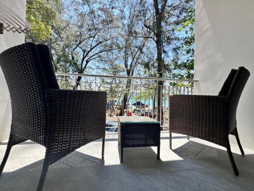 two wicker chairs and a table on a balcony at Phuket Muay Thai Hotel Rawai Beach in Rawai Beach