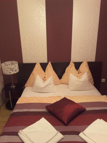 a hotel room with a bed with white pillows at Isabell Apartments Győr in Győr