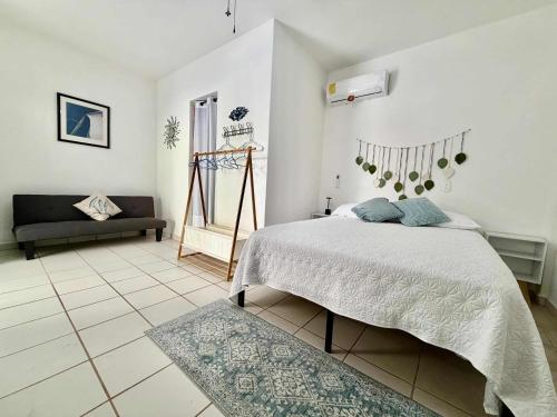 ein Schlafzimmer mit einem Bett und einer Couch in der Unterkunft Vista Boca in Puerto Vallarta