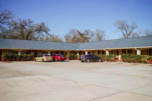 Un edificio con coches aparcados en un estacionamiento. en REGENCY INN - CHANNELVIEW, en Channelview