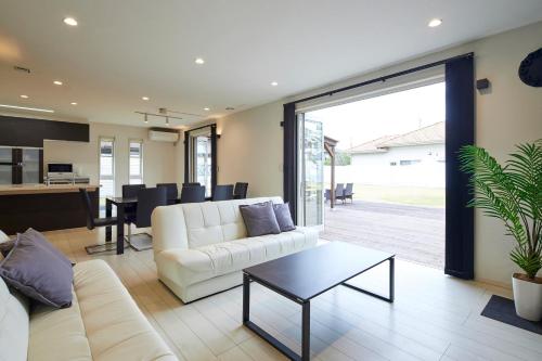 a living room with a white couch and a table at The Garden Villa 九十九里ー遊び充実の海近リゾート別荘を最大15名で一棟貸切 in Shirako