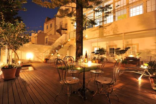 a table and chairs on a deck at night at Fonte Da Foz in Figueira da Foz