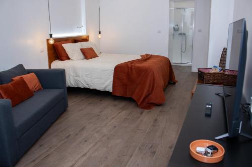a living room with a bed and a blue couch at AngraHouse in Angra do Heroísmo