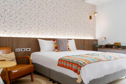 a bedroom with a bed and a table and a chair at Xi Mu in Taitung City