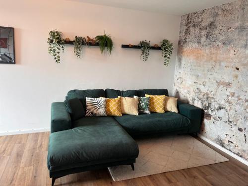 a green couch sitting in a living room at Chrisma Apartments in Düsseldorf