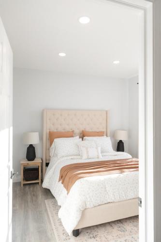 a white bedroom with a large bed and two lamps at Modern Condo Near Wright-Patt Shops & Dining in Beavercreek