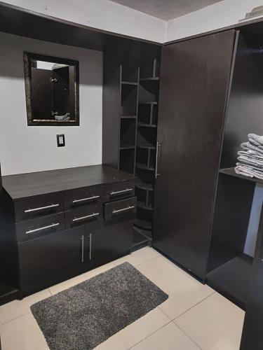 a black closet with black cabinets and a mirror at Hospedaje La Patrona in Chignahuapan