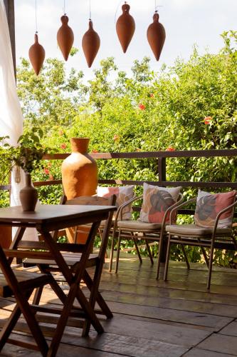 a patio with chairs and a table and a vase at Pousada Unaí - Casa Flor in Fernando de Noronha