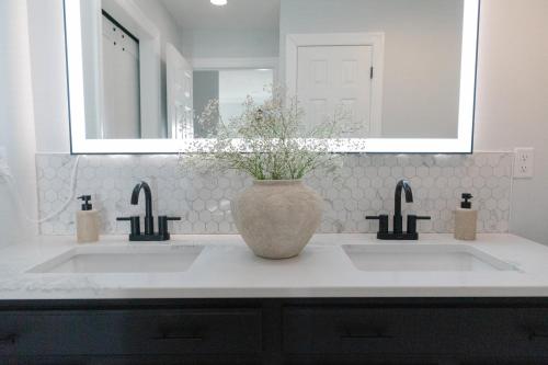 a bathroom with two sinks and a vase with flowers at Modern Condo Near Wright-Patt Shops & Dining in Beavercreek