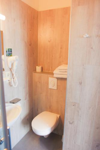 a bathroom with a white toilet and a sink at Hotel Stangl in Hamm