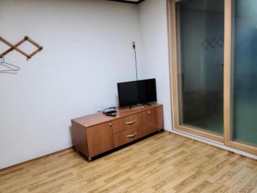 a room with a tv on a wooden dresser in a room at Chuncheon Saemmul Dungji Pension in Chuncheon