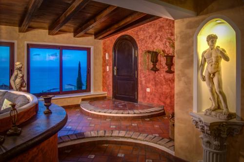 a bathroom with a tub and a statue of a man at Nido Paraiso in Santa Úrsula