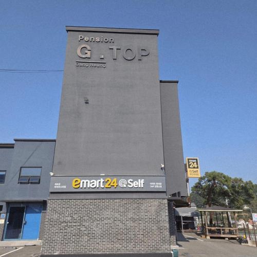 a building with a sign on the side of it at Gangneung Jitap Pension in Gangneung