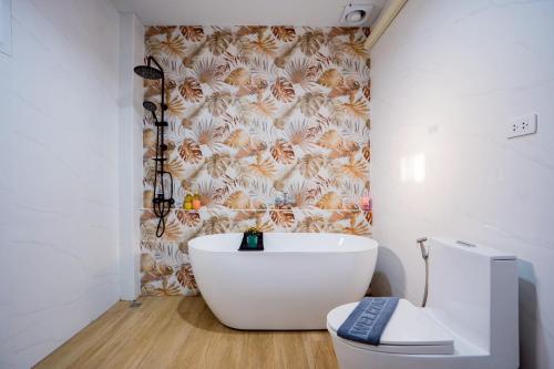 a bathroom with a white tub and a toilet at Only U Home-Stay Villa Huahin in Hua Hin