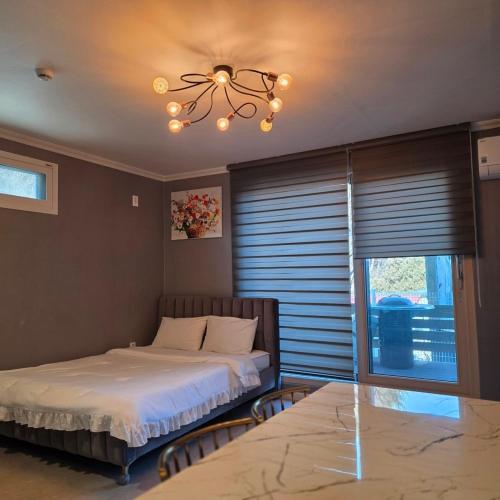 a bedroom with a bed and a chandelier at Gangneung Moan Pension in Gangneung