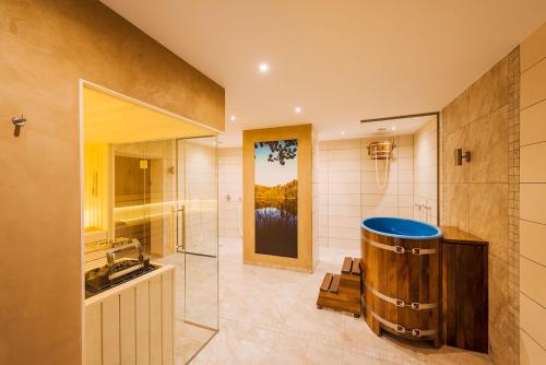 ein Badezimmer mit einer großen Holzbadewanne und einem Waschbecken in der Unterkunft Hotel Reindahls in Wilkendorf