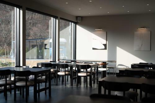 a dining room with tables and chairs and windows at Chaeonjae Gongju in Gongju