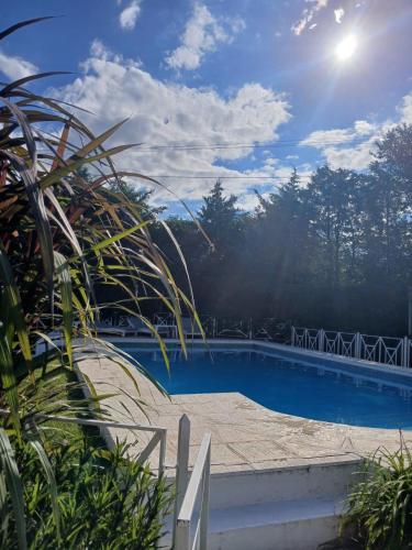 a swimming pool with the sun in the sky at Cantonavi Cabañas in Mina Clavero