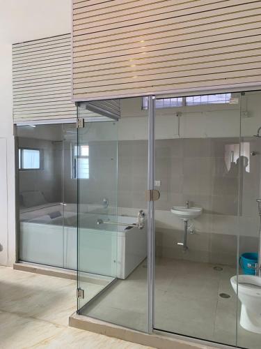 a bathroom with a glass shower and a sink at Ghate rooms in Nagpur