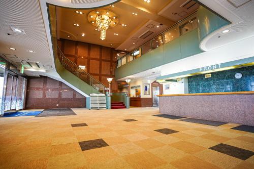 an empty lobby with a staircase in a building at Trip7湯沢天空温泉ホテル in Yuzawa