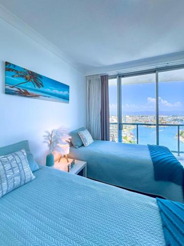 two beds in a bedroom with a view of the ocean at Deluxe Chevron Renaissance in Gold Coast