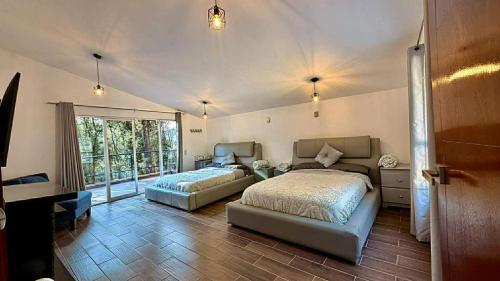 a bedroom with two beds and a couch in it at Villa 2 Senderó del Bosque in Omitlán de Juárez