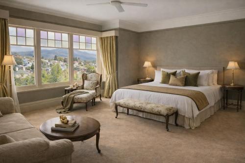 a bedroom with a bed and a chair and a couch at Grande Vue Hotel in Hobart