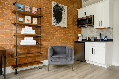 a kitchen with a chair and a brick wall at Bright Downtown Studio near Yale & East Rock! in New Haven