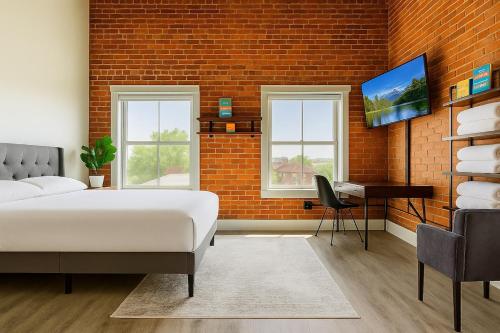 a bedroom with a bed and a desk and a brick wall at Bright Downtown Studio near Yale & East Rock! in New Haven