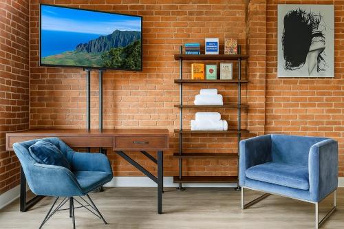 a room with a desk and two chairs and a television at Bright Downtown Studio near Yale & East Rock! in New Haven