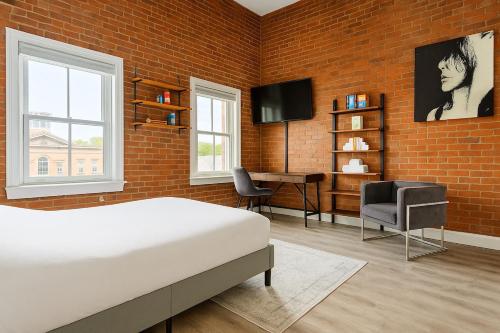 a bedroom with a bed and a brick wall at Bright Downtown Studio near Yale & East Rock! in New Haven
