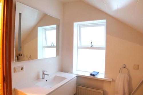 bagno con lavandino e specchio di Hvammur Apartments a Höfn