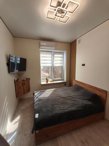 a bedroom with a bed and a flat screen tv at АппартОтель,Софія,пл Соборна in Dnipro