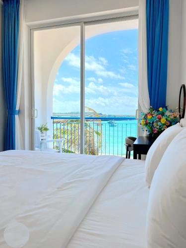 a bedroom with a view of the ocean at Babylon Hotel Phu Quy in Cu Lao Thu