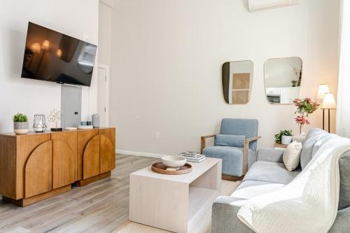 a living room with a couch and a tv at Central 2BR Near Yale WiFi with Washer and Dryer in New Haven