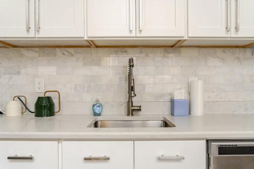 a kitchen counter with a sink and white cabinets at Central 2BR Near Yale WiFi with Washer and Dryer in New Haven