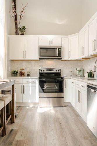 a white kitchen with a stove and a microwave at Central 2BR Near Yale WiFi with Washer and Dryer in New Haven