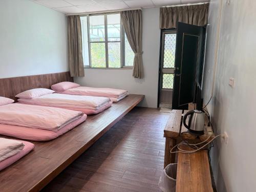 a room with four beds and a flat screen tv at Tanapavana閒雲居 in Alishan