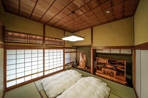 a room with two beds in a room with windows at Yuen in Beppu