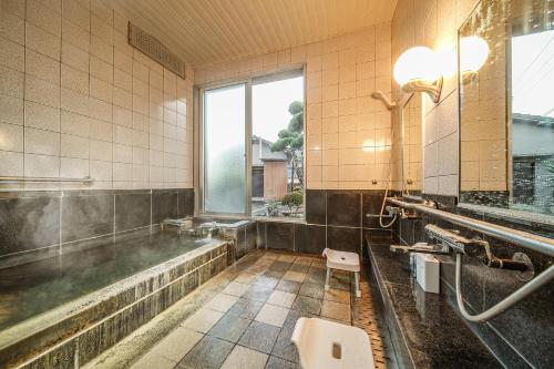 a bathroom with a sink and a bath tub at Yuen in Beppu