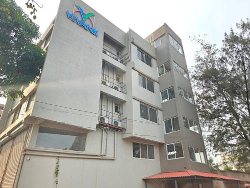 a building with a sign on the side of it at Hotel Vivank in Kolhapur