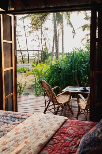 a bedroom with a bed and a view of a porch at Villa Fiesta - Beachfront Getaway in Verna