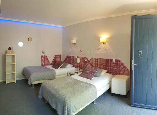 a hotel room with two beds and a couch at Logis Hôtel Restaurant Les Capucins in Avallon