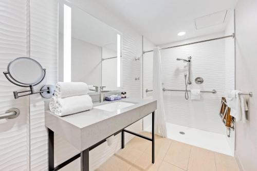 a white bathroom with a sink and a shower at The Capitol Hotel Downtown, an Ascend Collection Hotel in Nashville