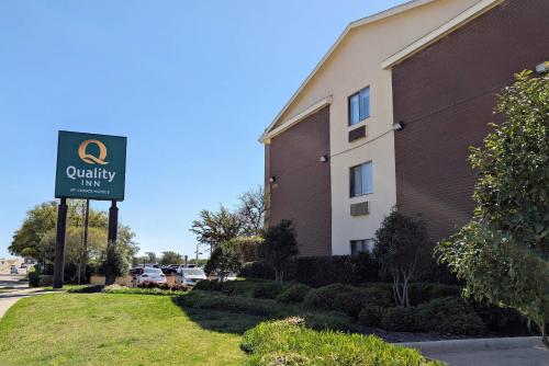 a sign for a quality hotel in front of a building at Quality Inn DFW Airport North in Irving